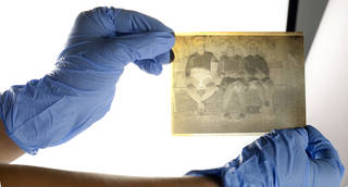 gloved hands holding negative